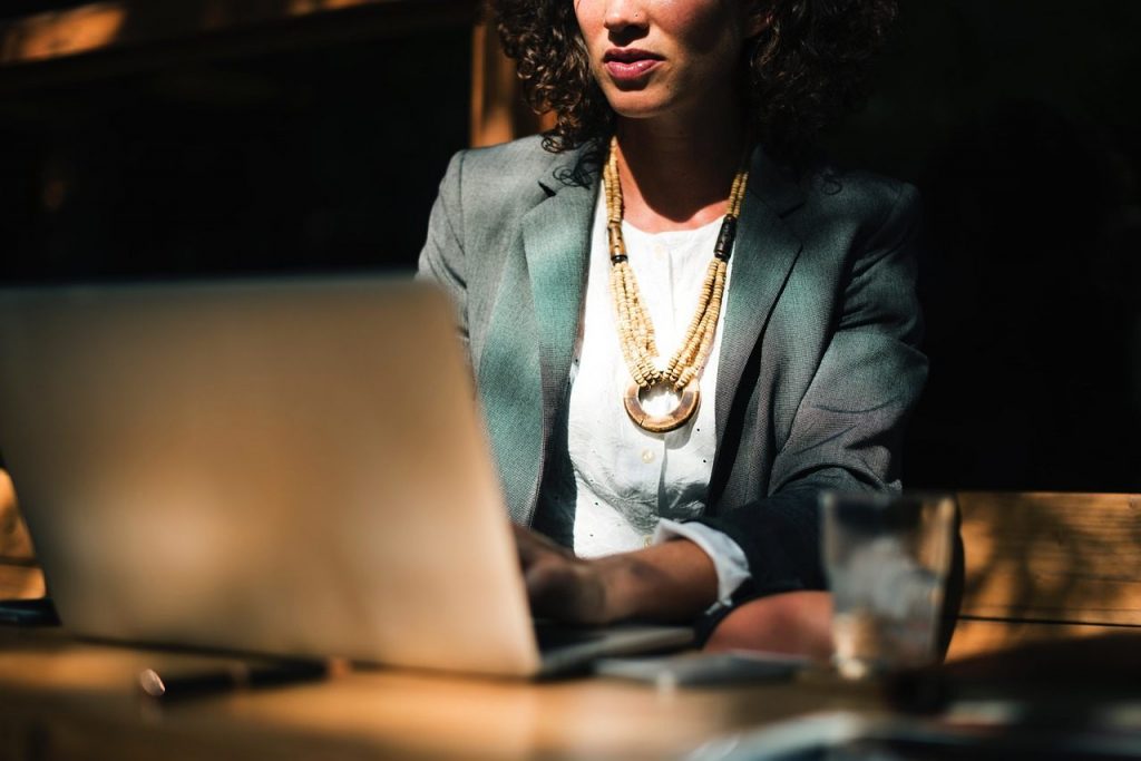 mulher escrevendo em computador portátil