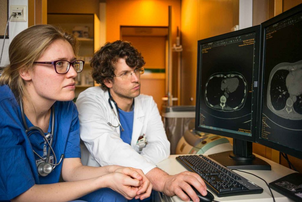 médicos observando tomografia num computador