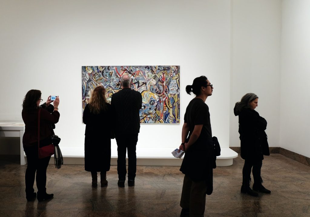 pessoas visitando uma galeria de pintura