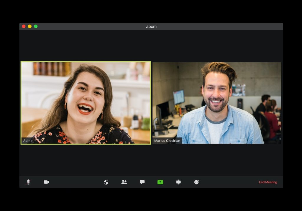 ecrã de computador exibindo videochamada com dois interlocutores - um homem e uma mulher - sorrindo