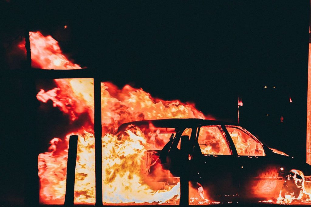 Instabilidade social: carro em chamas durante protestos de rua 